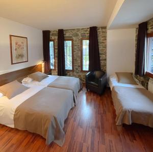a hotel room with two beds and two windows at Hotel Amoretes in La Molina