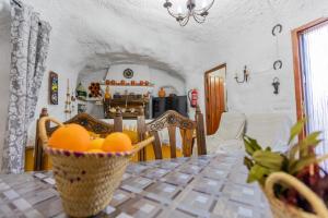 a dining room table with a basket of oranges on it at Casa cueva con encanto in Terque