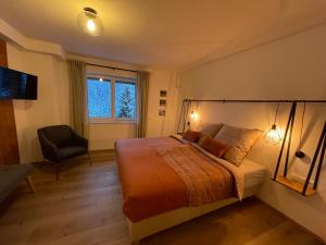 1 dormitorio con 1 cama, 1 silla y 1 ventana en Wonder & Wander, en Ehrwald