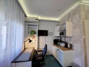 a small kitchen with a desk and chairs in a room at Summer House emeleti szoba in Debrecen