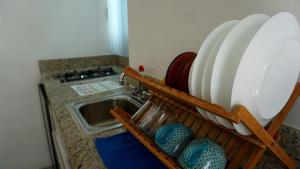 a kitchen with a sink and a counter with dishes at Selva y Mar Apart Hotel in Playa del Carmen