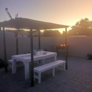 - une table et un banc sous un parasol sur une terrasse dans l'établissement BoHo, à Velddrif