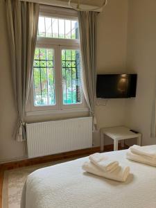 um quarto com uma cama com duas toalhas brancas em Anavros beach house em Volos