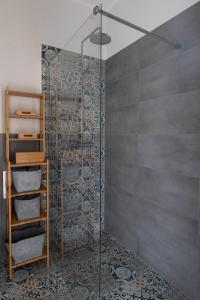 グダニスクにあるOlives Marina Apartment Gdańskのバスルーム(ガラスドア付きのシャワー付)
