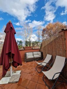 a patio with two chairs and an umbrella at ELEGANT ROOMS PARIOLI in Rome