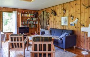 a living room with a blue couch and wooden walls at Stunning Home In Magnor With Kitchen in Magnor