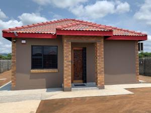 une petite maison avec un toit rouge dans l'établissement Lion House, 3 bedroom House next to Pilanesberg and Sun City, à Mogwase