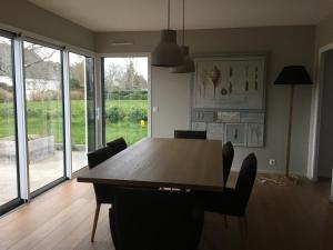 a dining room with a wooden table and chairs at Embruns et Sarrasin in Combrit