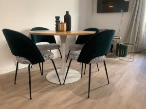 a table with four chairs and a table with a table and a table and chairs at Appartement velouté in Dijon
