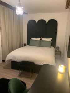 um quarto com uma cama grande e uma grande cabeceira. em Appartement velouté em Dijon