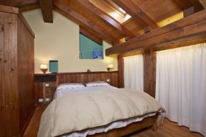um quarto com uma cama grande e paredes de madeira em Le Bibelot apartments em Nus
