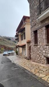 an empty street next to a stone building at Ζέφη in Arachova