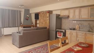 a kitchen and living room with a couch and a table at Ζέφη in Arachova