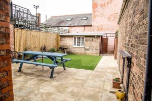 a patio with a picnic table in a backyard at Chequer - seafront 1 bed ground floor garden flat in Cleethorpes