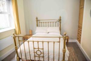 1 dormitorio con 1 cama con sábanas blancas y ventana en Chequer - seafront 1 bed ground floor garden flat en Cleethorpes