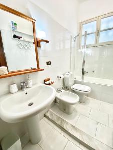 a white bathroom with a sink and a toilet at Ca del Mare - FREE Parking in La Spezia