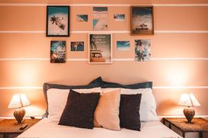 1 dormitorio con 1 cama con cuadros en la pared en Bacana Hotel Boutique, en Búzios
