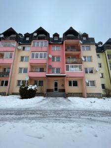a row of apartment buildings in the snow at Apartmán DoMa - Tatranská Lomnica in Tatranská Lomnica