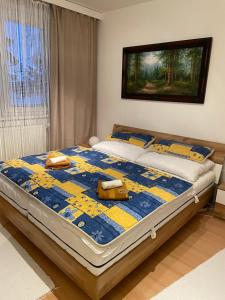 a bedroom with a bed with a blue and yellow quilt at Apartmán DoMa - Tatranská Lomnica in Tatranská Lomnica