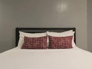 a bed with two brown pillows and a black headboard at Penthouse , 1BR , Loft , WIFI up to 100mbps , Cozy in Cebu City