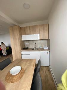 Apartman LED-Treska في كوباونيك: مطبخ مع طاولة خشبية ومغسلة
