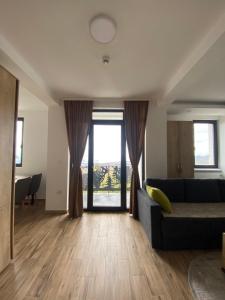 - un salon avec un canapé et une grande fenêtre dans l'établissement Apartman LED-Treska, à Kopaonik