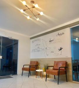 una sala de reuniones con 2 sillas y un dibujo en la pared en Pousada Ventura, en Anchieta