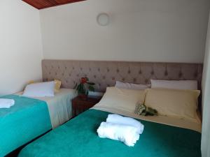 2 Betten nebeneinander in einem Zimmer in der Unterkunft Hospedagem Virginia Bracelli in Campos do Jordão