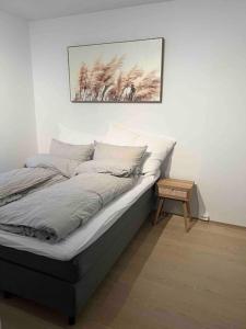 1 cama en una habitación con una foto en la pared en Nydelig leilighet med sentral beliggenhet. en Tønsberg