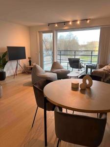 a living room with a table and chairs at Nydelig leilighet med sentral beliggenhet. in Tønsberg