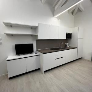 an empty kitchen with white cabinets and a sink at Smart Apartments Palazzo Mazzini in Rovereto +24 photos