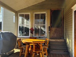 a wooden table and chairs on the porch of a house at House & loft, pool table, ping-pong, fireplace, AC in Ayer's Cliff +31 photos