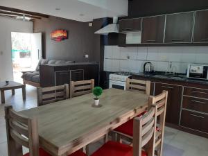 a kitchen with a wooden table and a dining room at Raíces Departamento 1 in San Rafael