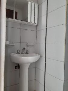a white bathroom with a sink and a mirror at Raíces Departamento 1 in San Rafael