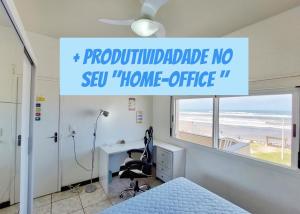 a sign in a room with a bed and a desk at Incrível Sacada à Beira Mar APTO 3Q in Tramandaí