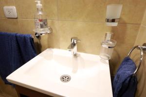 a white sink in a bathroom with blue towels at Departamento JUJUY in San Salvador de Jujuy