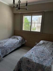 Un dormitorio con dos camas y una ventana. en LAM 39 en pleno centro de la cuidad, en Bahía Blanca