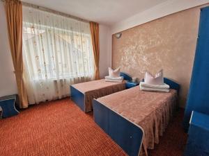 a hotel room with two beds and a window at Hotel Belvedere in Piatra Neamţ