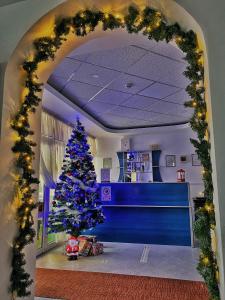 Un árbol de Navidad en medio de una habitación en Hotel Belvedere, en Piatra Neamţ