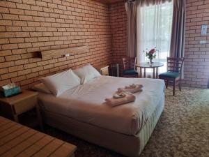 Una habitación de hotel con una cama con toallas. en La Cochon Rose Motel, en Saint Arnaud