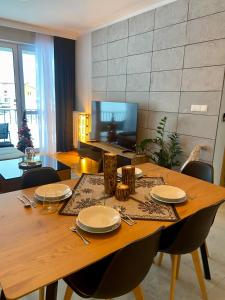 een eettafel met borden en keukengerei erop bij Górski Apartament Olimpijska 1L in Szczyrk