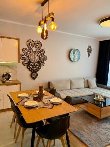 een woonkamer met een tafel en een bank bij Górski Apartament Olimpijska 1L in Szczyrk