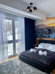a bedroom with a bed and a large window at Górski Apartament Olimpijska 1L in Szczyrk