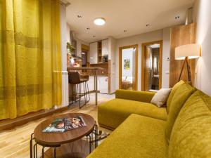 Kalman SPA&GYM في زلاتيبور: غرفة معيشة مع أريكة خضراء وطاولة