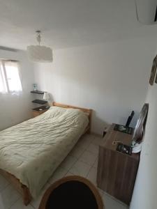 een slaapkamer met een bed en een houten bureau bij Cannet le lac in Le Cannet