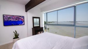 a bedroom with a white bed and a large window at Riverfront II, piso 2, suite vista al rio, Puerto Santa Ana, Guayaquil in Guayaquil