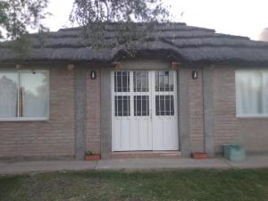 Casa de ladrillo con puerta blanca y ventanas en Cabaña Doña Alicia en San Rafael