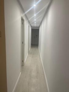 an empty hallway with white walls and wood floors at Cozy Apartment Near Sagrada Familia in Barcelona