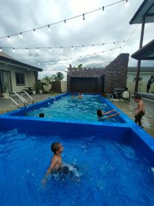 a group of children playing in a swimming pool at MAMA homestay in Bagan Serai