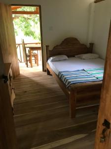Schlafzimmer mit einem Bett und einer Tür, die zu einem Tisch führt in der Unterkunft Gaga addara resort in Habarana